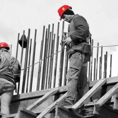 Trabajadores de la construcción en obra estructural en Madrid con cascos de seguridad