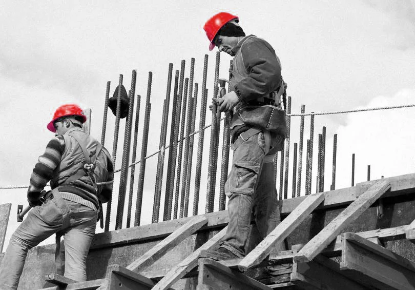 Trabajadores de la construcción en obra estructural en Madrid con cascos de seguridad